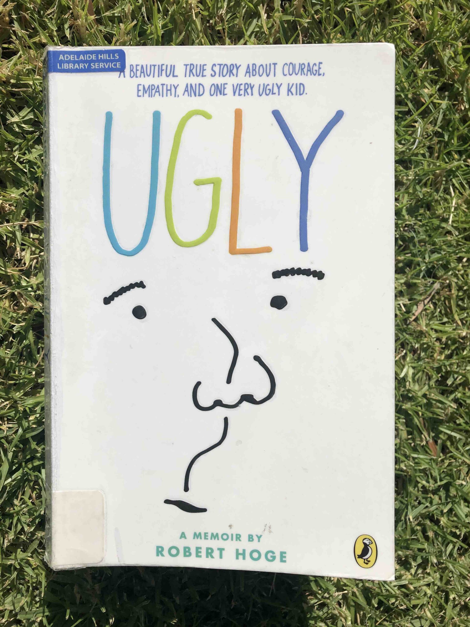 Cover of the book 'Ugly. The word 'Ugly' is in coloured letters at the top and below is a black and white sketch of a face.